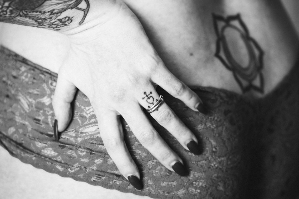 Black & White boudoir photo of a woman's tattooed hand on her tattooed rear end