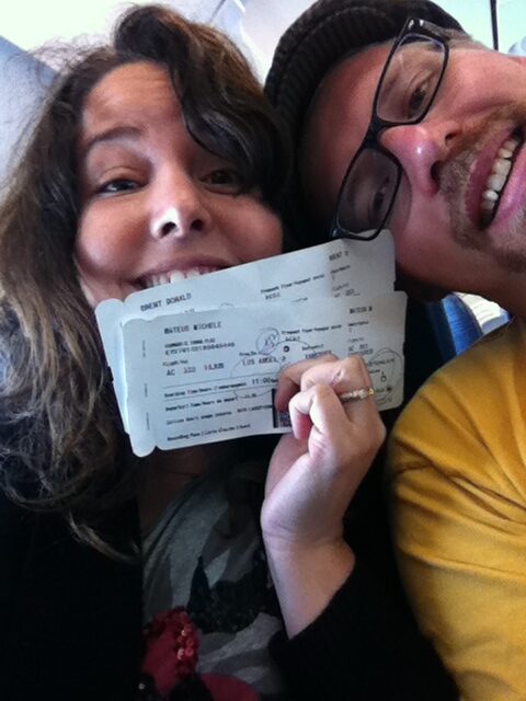 Man and woman on a plane holding plane tickets excited about their trip
