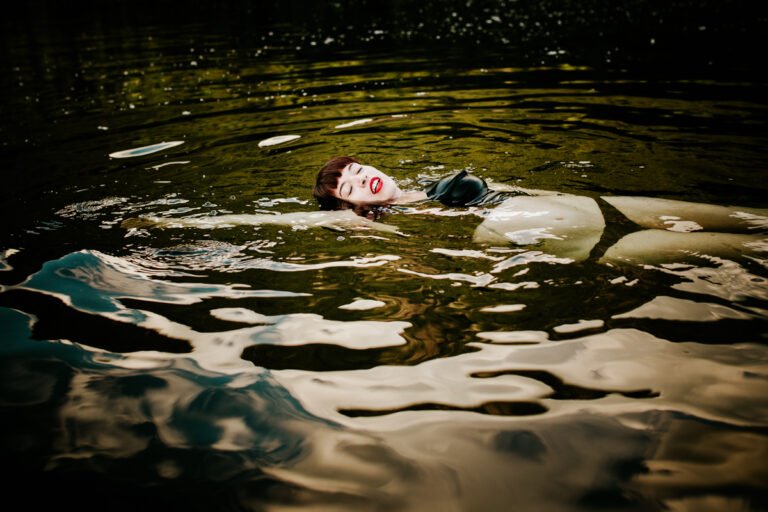 woman in black bikini floating on her back in a body of water