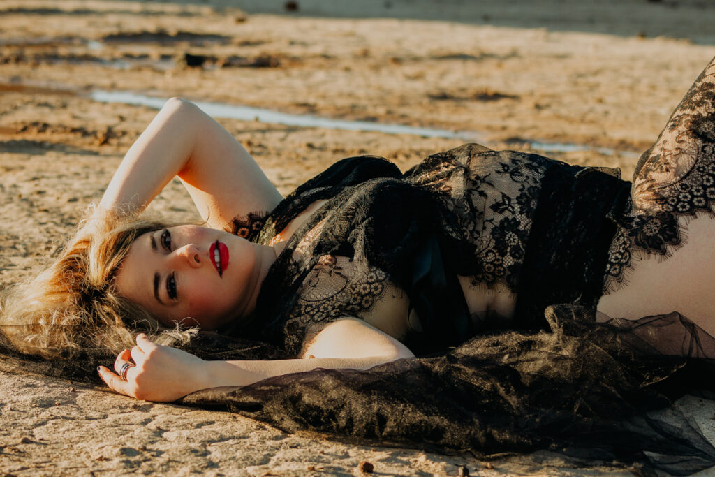 Woman in lace outfit laying on her back on the ground