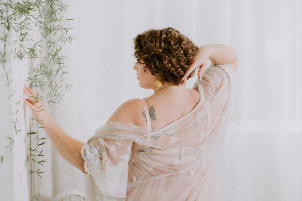 plus size boudoir photo of woman standing in lingerie