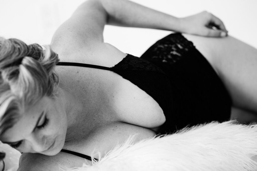 plus size boudoir photo in black and white of woman wearing lingerie