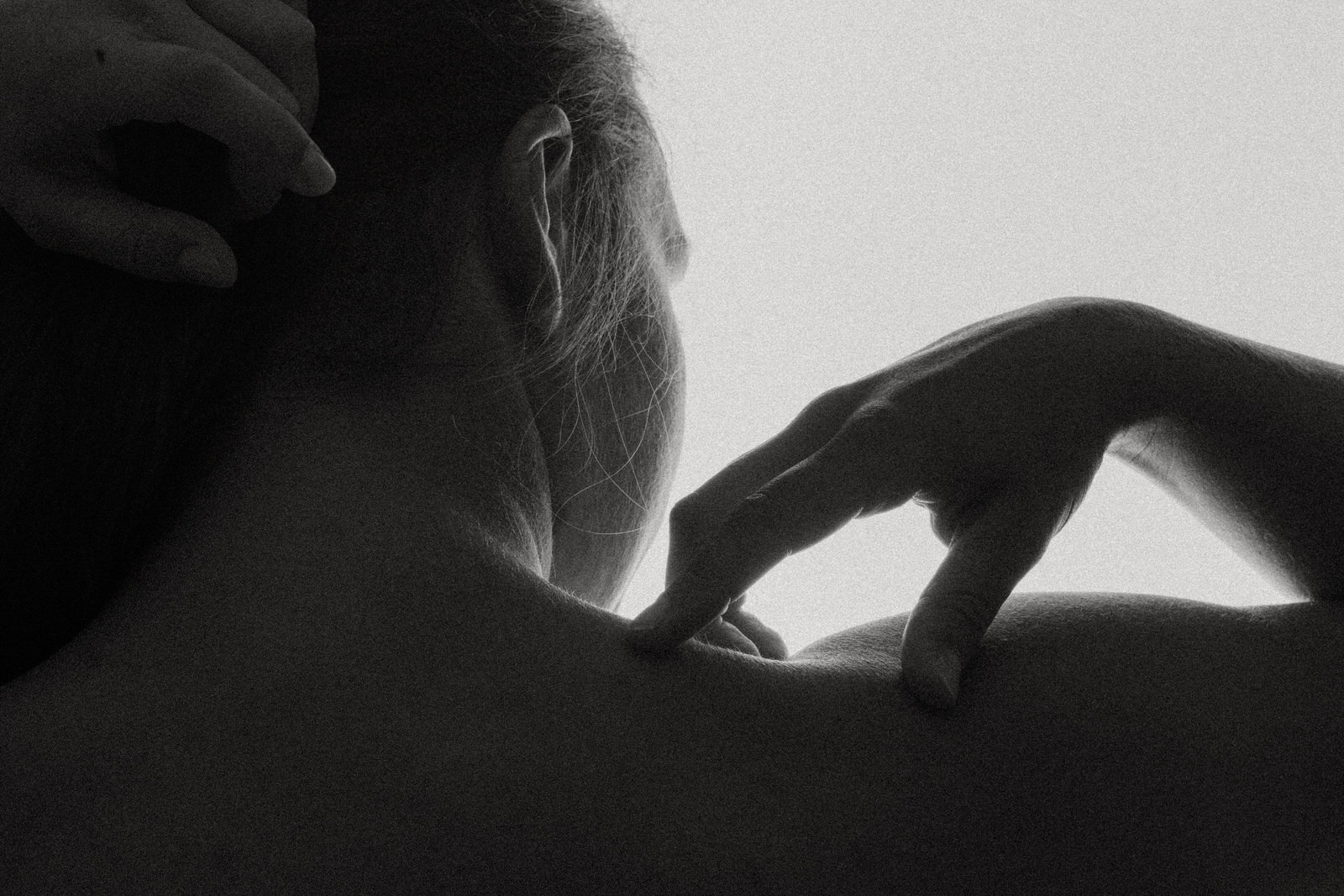 vancouver boudoir black and white photo of woman's shoulder and hand holding hair off back