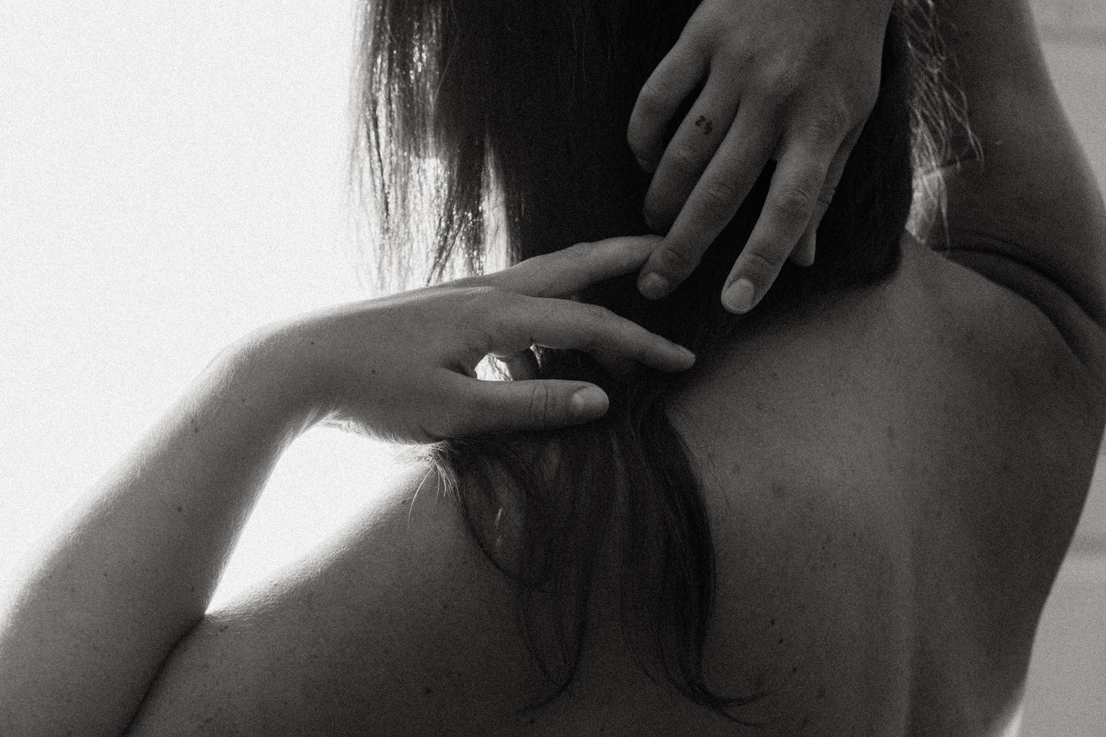woman's fingers touching by her naked shoulder
