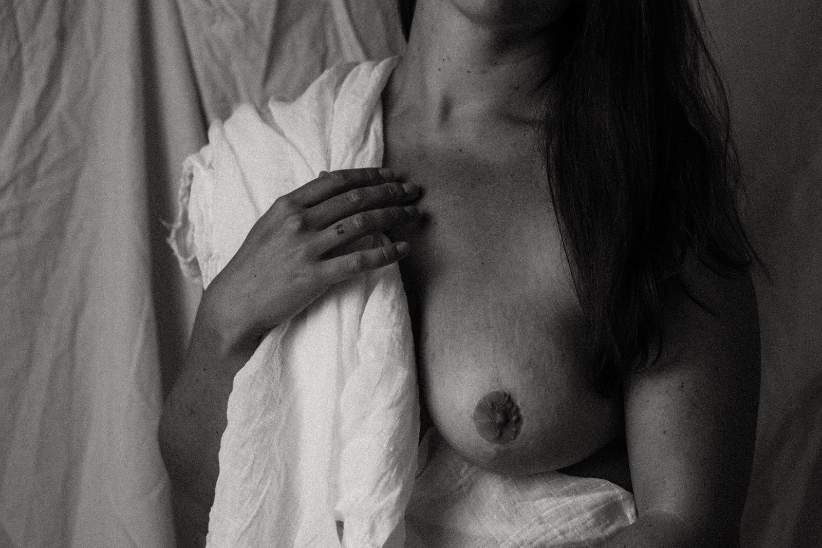 vancouver boudoir image of woman's breast and the other covered by a cloth