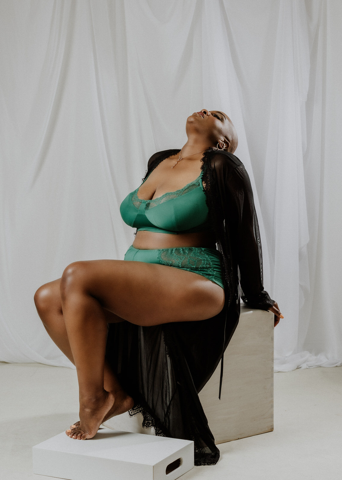 vancouver boudoir photographer image of plus size black woman with alopecia wearing lingerie and sitting on a block