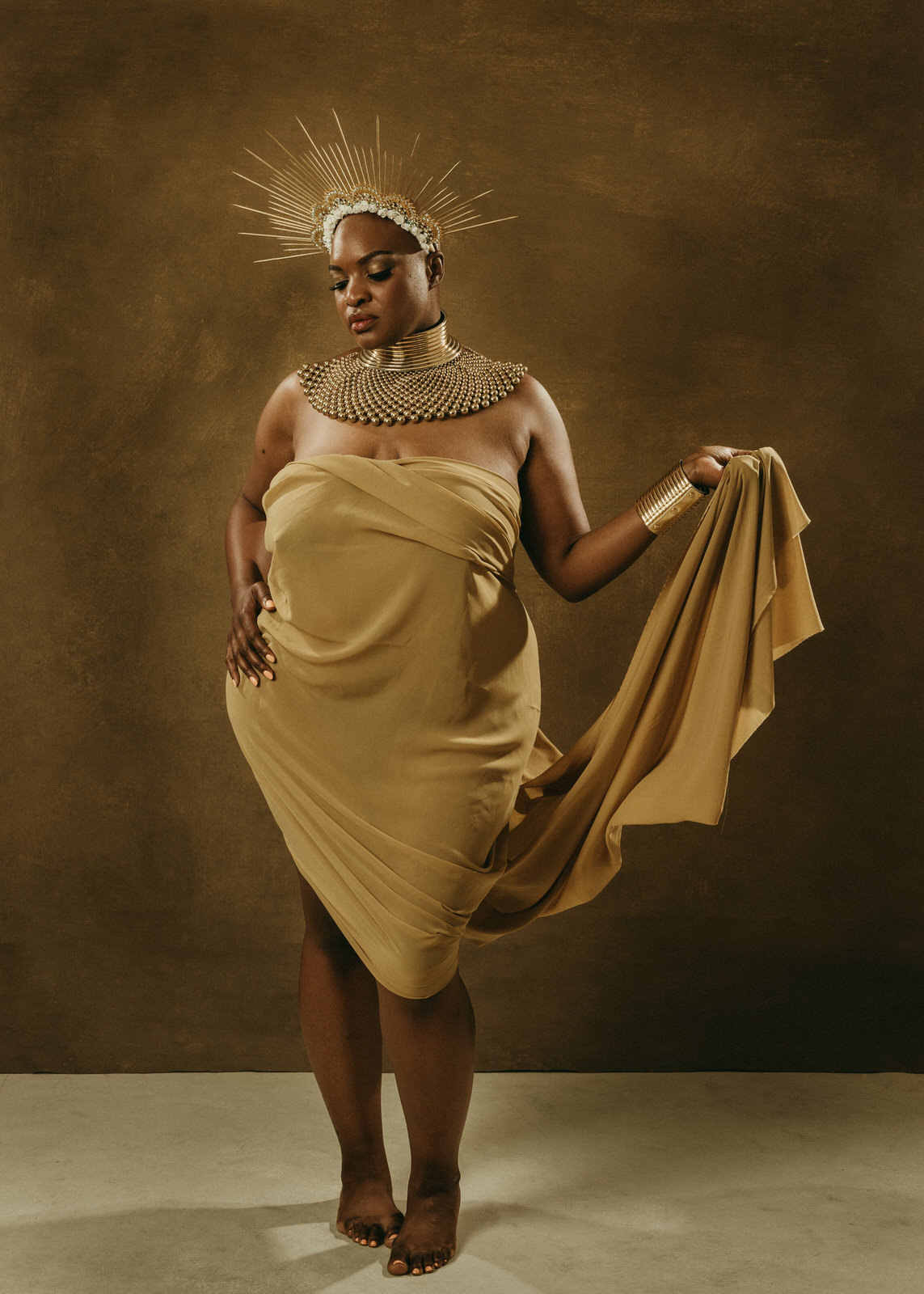 vancouver boudoir photographer image of plus size black woman with alopecia wearing gold fabric and sun crown