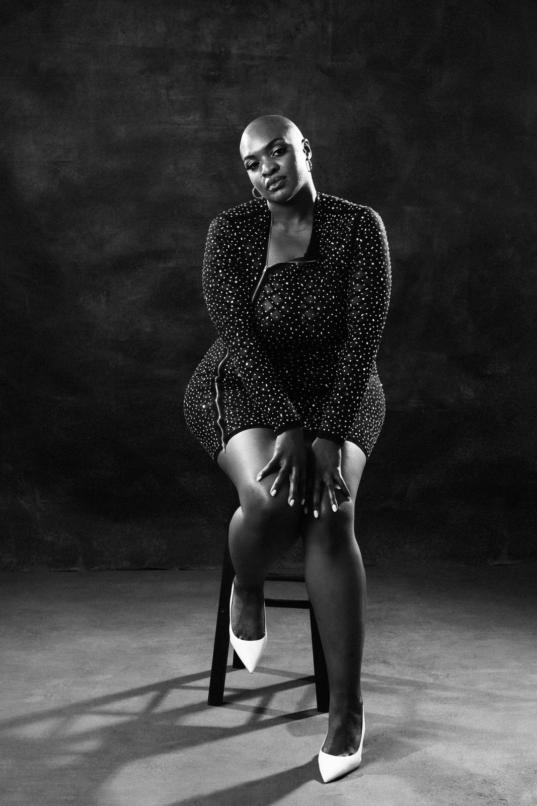 vancouver boudoir photographer image of plus size black woman with alopecia sitting on stool